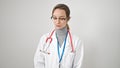 Young caucasian woman doctor standing with serious expression looking down over isolated white background Royalty Free Stock Photo