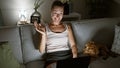 Young caucasian woman with dog doing video call using laptop sitting on the sofa at home Royalty Free Stock Photo