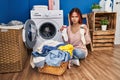 Young caucasian woman doing laundry holding socks skeptic and nervous, frowning upset because of problem Royalty Free Stock Photo