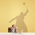 Young woman dreaming about fantasy worlds during her work in office. Becoming a legend. Shadow of dreams on the wall Royalty Free Stock Photo