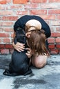 Young caucasian woman embraÃÂes little black puppy of Staffordshire Bullterrier breed. Royalty Free Stock Photo