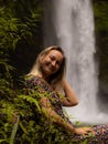 Young Caucasian woman enjoying waterfall landscape in tropical forest. Woman portrait. Energy of water. Travel lifestyle. Nung