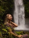 Young Caucasian woman enjoying waterfall landscape in tropical forest. Woman portrait. Energy of water. Travel lifestyle. Nung