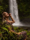 Young Caucasian woman enjoying waterfall landscape in tropical forest. Woman portrait. Energy of water. Travel lifestyle. Nung