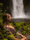 Young Caucasian woman enjoying waterfall landscape in tropical forest. Woman portrait. Energy of water. Travel lifestyle. Nung