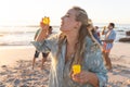Young Caucasian woman enjoys blowing bubbles on the beach at sunset Royalty Free Stock Photo