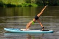 Young caucasian woman exercises yoga on SUP