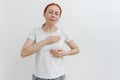 Young caucasian woman feeling breast pain, touching her chest. Brest cancer. White background, studio shoot Royalty Free Stock Photo