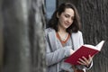 Young Caucasian woman in formal dress reading book outdoors Royalty Free Stock Photo