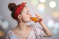 Young caucasian woman girl drinking a glass of orange or mango fruit juice or cocktail. Fresh summer party concept