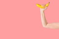 Young Caucasian woman girl holds in hand banana imitating dumbbell for muscles workout. Healthy active lifestyle vegan diet