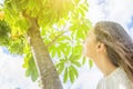 Young Caucasian Woman Girl with Long Chestnut Hair Standing under tree looking up in the sky green foliage Royalty Free Stock Photo