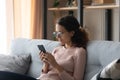 Caucasian woman in glasses using cellphone at home