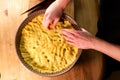 young caucasian woman hands push shortcrust pastry into a baking tin