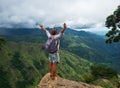 Young caucasian woman hiker with backpack standing on top of the mountain and enjoying valley view in Ella peak Royalty Free Stock Photo