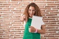 Young caucasian woman holding art notebook pointing to you and the camera with fingers, smiling positive and cheerful Royalty Free Stock Photo