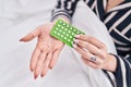 Young caucasian woman holding birth control pills at bedroom Royalty Free Stock Photo