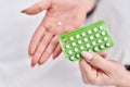 Young caucasian woman holding birth control pills at bedroom Royalty Free Stock Photo