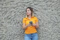 Young Caucasian woman holding with both hands a mobile phone and keeping connected