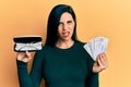 Young caucasian woman holding glasses and swedish krona banknotes in shock face, looking skeptical and sarcastic, surprised with Royalty Free Stock Photo