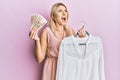 Young caucasian woman holding hanger with t shirt and russian ruble banknotes angry and mad screaming frustrated and furious, Royalty Free Stock Photo