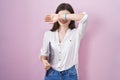 Young caucasian woman holding laptop smiling cheerful playing peek a boo with hands showing face Royalty Free Stock Photo