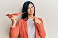 Young caucasian woman holding paper airplane smiling happy pointing with hand and finger Royalty Free Stock Photo