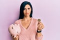 Young caucasian woman holding piggy bank and bitcoin depressed and worry for distress, crying angry and afraid Royalty Free Stock Photo