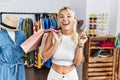 Young caucasian woman holding shopping bags at retail shop smiling amazed and surprised and pointing up with fingers and raised Royalty Free Stock Photo