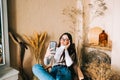 Young caucasian woman holding smartphone looking on cell using mobile phone technology at home Royalty Free Stock Photo