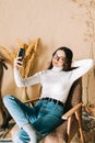 Young caucasian woman holding smartphone looking on cell using mobile phone technology at home taking selfie for social media or Royalty Free Stock Photo