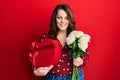 Young caucasian woman holding valentine gift and flowers smiling with a happy and cool smile on face Royalty Free Stock Photo