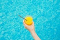 Young Caucasian Woman Holds Glass of Freshly Pressed Tropical Fruits Orange Juice with Striped Straw by Swimming Pool Royalty Free Stock Photo