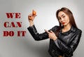 A young Caucasian woman in a leather jacket, holding chicken eggs in her hand and pointing at them with her finger. Feminism, girl