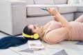 Young caucasian woman listening to music lying on floor at home Royalty Free Stock Photo