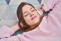 Young caucasian woman listening to music lying on floor at home Royalty Free Stock Photo