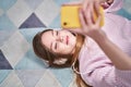 Young caucasian woman listening to music lying on floor at home Royalty Free Stock Photo