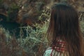 Young caucasian woman with long chestnut hair in checkered wool plaid looks at horizon standing in field meadow. Cozy autumn Royalty Free Stock Photo