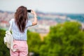 Young caucasian woman making photo of european old city by mobile phone from the observation place Royalty Free Stock Photo