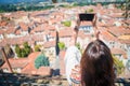 Young caucasian woman making photo of european old city by mobile phone from the observation place Royalty Free Stock Photo