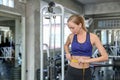 Young caucasian woman measuring waist in gym. Slim woman measuring her thin waist with a tape measure. smiling people with measure