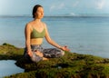 Young woman, meditating, practicing yoga and pranayama at the beach. Sunset yoga practice. Hands in gyan mudra. Melasti beach, Royalty Free Stock Photo