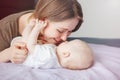 Young Caucasian woman mother hugging kissing playing with cute newborn baby boy girl child at home. Royalty Free Stock Photo