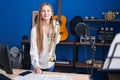 Young caucasian woman musician composing song holding trumpet at music studio Royalty Free Stock Photo