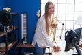 Young caucasian woman musician composing song holding trumpet at music studio Royalty Free Stock Photo