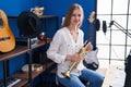 Young caucasian woman musician smiling confident holding trumpet at music studio Royalty Free Stock Photo