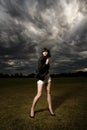 Young caucasian woman in a park with stormy sky