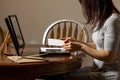 A young caucasian woman is placing a printed photograph into a picture frame with kickstand.