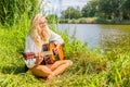 Blonde woman playing the guitar at river Royalty Free Stock Photo