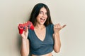 Young caucasian woman playing video game holding controller pointing thumb up to the side smiling happy with open mouth Royalty Free Stock Photo